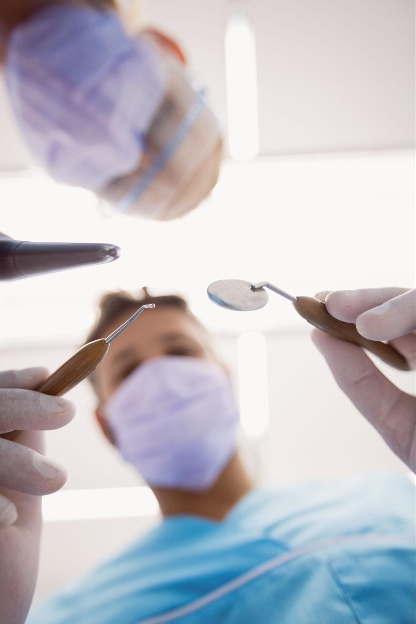 dentist with dental hygienist examining patient