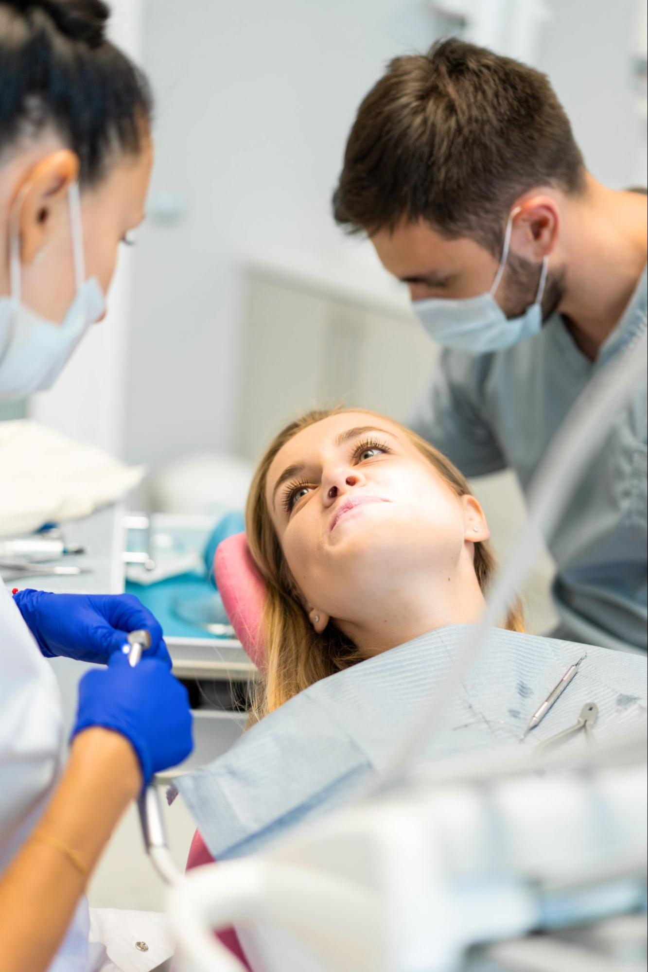 patient getting examined by dentist and hygienist